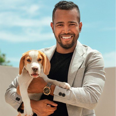 Juan Andrés Girón sonriendo, con un beagle en brazos